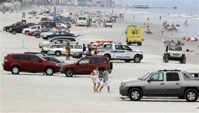 Vehicles share the beach with swimmers and sunbathers in Daytona Beach Shores, Fla. Safety concerns over cars driving on Volusia County beaches have risen this year with the deaths of two 4-year-old children. 